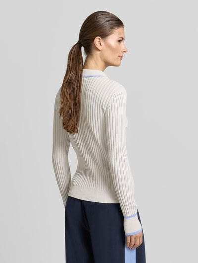 Modelka nosi Strickpullover mit V-Ausschnitt od KARO KAUER EXKLUSIV, bawełna, Slim Fit, kremowy, prążkowana faktura, widok od tyłu.