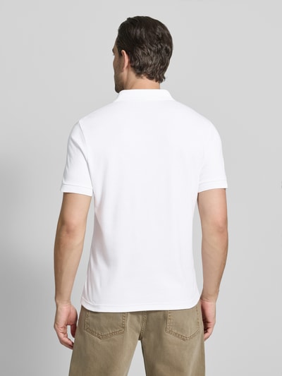 Männermodel trägt Regular Fit Poloshirt aus reiner Baumwolle von Lacoste, Optik: Unifarben, Logo-Detail, Ganzkörperansicht Rückansicht.