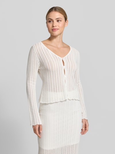 Frauenmodel trägt Cardigan mit V-Ausschnitt und Knopfleiste von Rich & Royal aus Reine Baumwolle, Straight Fit, Ajour-Strick, Trompetenärmel, Rückenlänge 52 cm, Ärmellänge 62 cm, Weiß, Ganzkörperansicht von vorne.