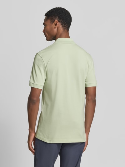 Männermodel trägt Slim Fit Poloshirt aus Baumwoll-Mix Modell 'PASSENGER' von BOSS Orange, Optik: Unifarben, Ganzkörperansicht Rückansicht.