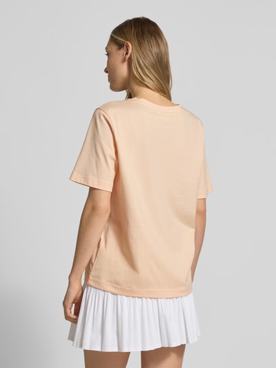 Frauenmodel trägt Relaxed Fit T-Shirt aus reiner Baumwolle von Lacoste in Unifarben mit Logo-Stitching, Rückansicht Ganzkörperansicht.