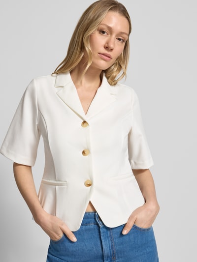 Frauenmodel trägt Blazer mit Viskose-Anteil Modell 'Kate' von ICHI in Weiß mit Reverskragen, Halbarm, durchgängiger Knopfleiste, Paspeltaschen, Tailliertem Schnitt, Elastischer-Material-Mix, Nahaufnahme Oberkörper.