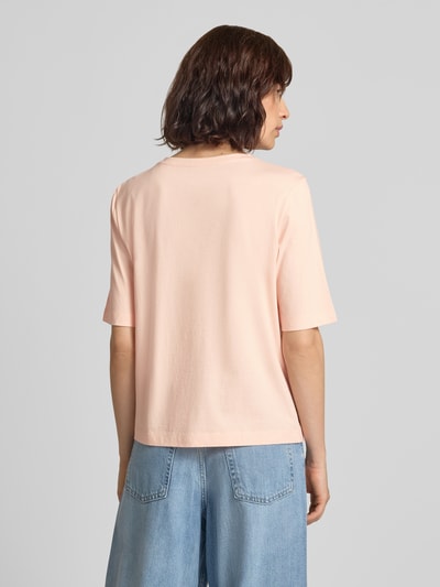Frauenmodel trägt T-Shirt mit Ziersteinbesatz und Rundhalsausschnitt von Marc Cain in zartem Rosa, reine Baumwolle, Regular Fit, Rückenansicht, Ganzkörperansicht Rückansicht.