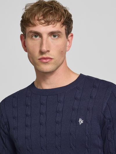 Männermodel trägt Slim Fit T-Shirt in Strick-Optik von REVIEW in Dunkelblau, reine Baumwolle, Logo-Stitching, Nahaufnahme Oberkörper.