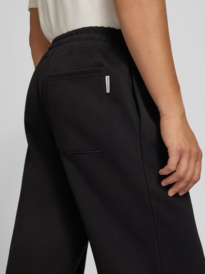 Männermodel trägt Straight Fit Sweatpants mit elastischem Bund von JACK & JONES, schwarze Baumwollmischung, Detailaufnahme, Nahaufnahme Hüfte