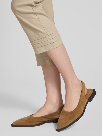 Frauenmodel trägt Caprihose aus Viskose-Mix Modell 'Ina' von STEHMANN in Beige mit Drapierungen, Slim Fit, Nahaufnahme Unterschenkel.