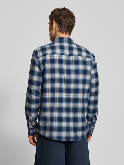 Męski model nosi koszulę casualową Relaxed Fit Freizeithemd aus reiner Baumwolle model 'COTTON CHECK LONGSLEEVE' von ARMEDANGELS w niebieską kratę, tekstura miękka, widok całej sylwetki z tyłu, kontekst Herren Freizeithemd von ARMEDANGELS.