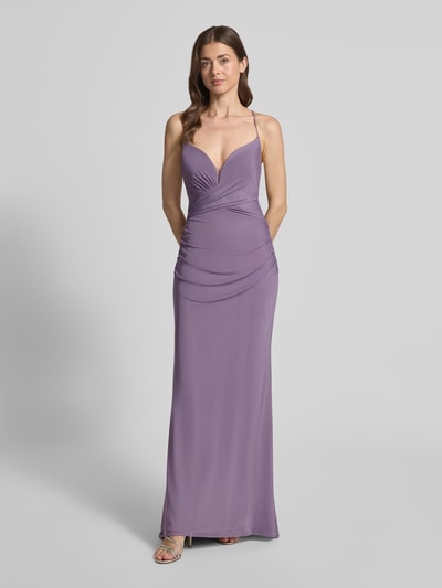 Frauenmodel trägt Abendkleid mit Rückenausschnitt von Laona in Lila mit Spaghetti-Trägern, V-Ausschnitt, Raffung, blickdichtem Unterrock, taillierter Passform, Schnürverschluss und Nahtreißverschluss, Ganzkörperansicht von vorne.