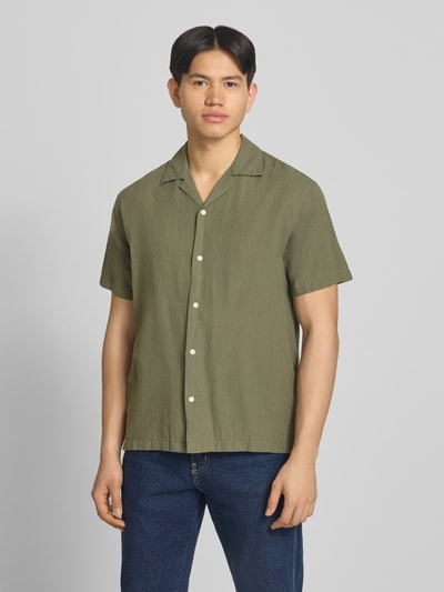 Männermodel trägt Regular Fit Freizeithemd aus Baumwoll-Leinen-Mix von Jack & Jones in Olivgrün mit Knopfleiste, Ganzkörperansicht von vorne. Rückenlänge 71 cm, Schulterbreite 50 cm, Ärmellänge 26 cm. Modell 'BREEZE', Reverskragen.