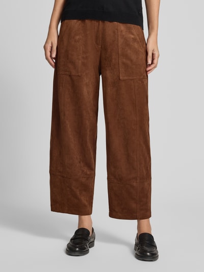Vrouwenmodel draagt Loose Fit kunstleerbroek met elastische band model 'Tilda' van MAC, bruin met zichtbare naden, dames leerbroek, detailopname voorzijde.