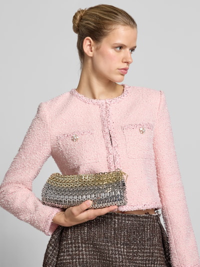 Frauenmodel trägt Clutch in Ketten-Optik von Rabanne in glänzendem Silber und Gold, rechteckige Form, Nahaufnahme Oberkörper.