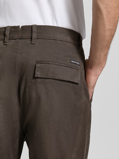 Mężczyzna nosi szerokie spodnie z mieszanki bawełny model 'Mossbo' od Marc O'Polo, brązowy kolor, tekstura gładka, detailaufnahme, kontekst: męskie szerokie spodnie od Marc O'Polo