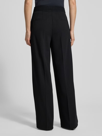Frauenmodel trägt Stoffhose mit weitem Bein und Bügelfalten von Betty Barclay, Material-Mix mit Stretch-Anteil, Paspeltaschen am Gesäß, Ganzkörperansicht Rückansicht.