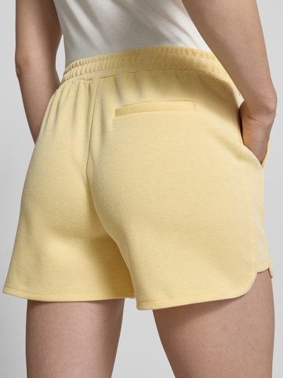 Frauenmodel trägt Shorts mit elastischem Bund Modell 'KATE PIQUE' von ICHI aus Baumwoll-Mix in Gelb, Regular-Fit, Detailaufnahme Rückansicht.