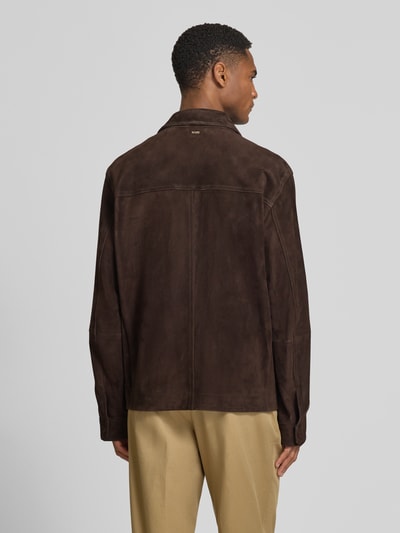 Männermodel trägt Regular Fit Lederjacke aus echtem Ziegenleder Modell 'C-MOLOT' von BOSS in nubuk lederoptik, donkerbruin met label-applicatie, lange mouw, omgeslagen kraag, drukknoopsluiting, rugpas, zij-ingestoken zakken en binnenzak; detailrijke textuur, productcontext inbegrepen, ganzkörperansicht rückansicht.