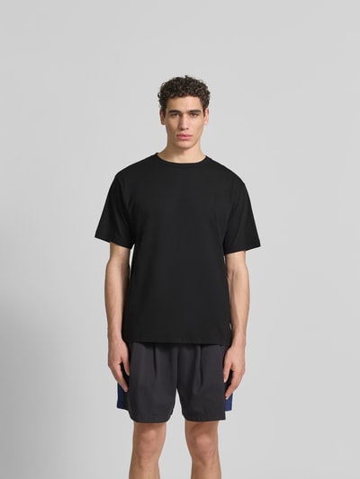 Männermodel trägt Herren T-Shirt mit Rundhalsausschnitt von Kenzo aus reiner Baumwolle, Relaxed-Fit, Logo-Stitching, ganzkörperansicht von vorne.