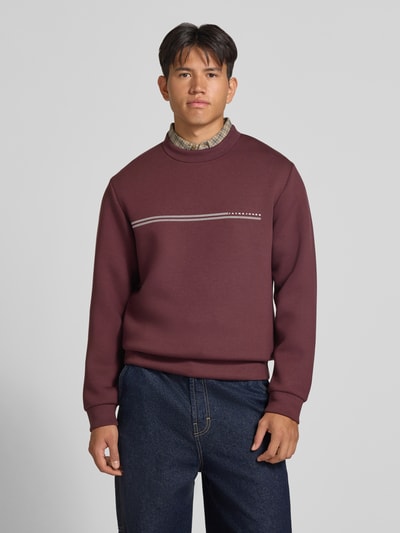Męski model nosi Relaxed Fit Sweatshirt mit Viskose-Anteil Modell 'Fusion' od JACK & JONES, Mieszanka materiałów z dodatkiem wiskozy, nadruk z logo, krój z długim rękawem, elastyczne wykończenia, długość tyłu 66 cm, długość rękawów 66 cm, widok całej sylwetki od przodu.