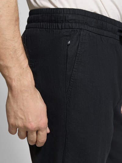 Männermodel trägt Shorts aus Leinen-Baumwoll-Mix Modell 'barton' von Matinique in Schwarz, elastischer Bund mit Tunnelzug, Nahaufnahme Oberkörper, Regular-Fit, Bundweite 43 cm, Innenbeinlänge 21 cm, Herrenkollektion.