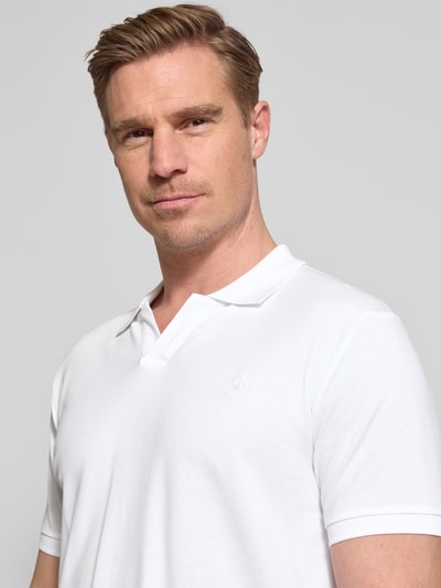 Männermodel trägt Slim Fit Poloshirt aus Baumwoll-Mix von Polo Ralph Lauren, Optik: Unifarben, Logo-Detail, Nahaufnahme Oberkörper.