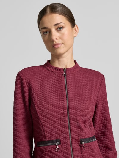 Frauenmodel trägt Regular Fit Kurzblazer mit Viskose-Anteil Modell 'NOS JULI' von Betty Barclay, dunkles Rot, strukturierte Textur, Nahaufnahme Oberkörper. Damen Kurzblazer von Betty Barclay