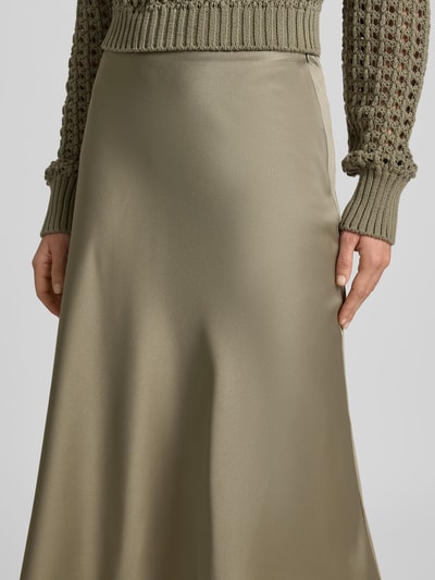 Frauenmodel trägt Midirock aus Satin mit Reißverschluss von Juvia in schmaler Passform und Midi-Länge, Nahaufnahme Oberkörper.