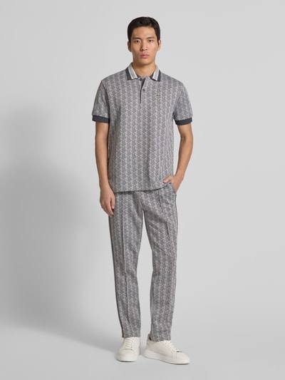 Männermodel trägt Regular Fit Poloshirt mit Baumwoll-Anteil von Lacoste, Optik: Unifarben, Allover-Muster, Kontraststreifen, Ganzkörperansicht von vorne.