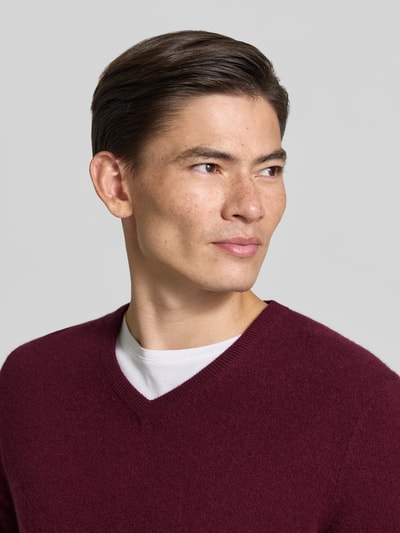Männermodel trägt Strickpullover aus Kaschmir mit V-Ausschnitt von Christian Berg Men in Bordeaux, Regular Fit, Nahaufnahme Oberkörper.