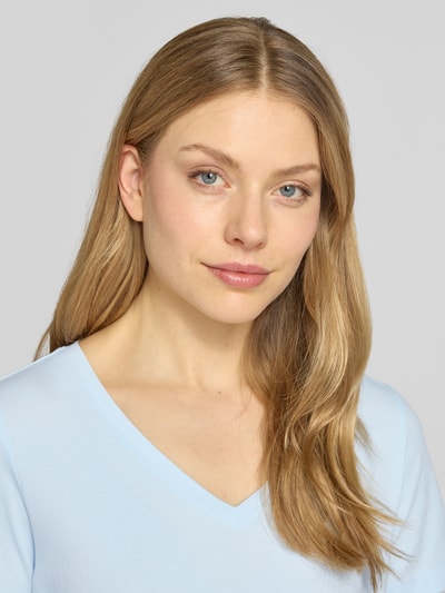 Modelka nosi Regular Fit T-Shirt aus Baumwoll-Mix od s.Oliver RED LABEL, jasnoniebieski, krój regular fit, jersey, dekolt V, krótki rękaw, zbliżenie na górną część ciała.