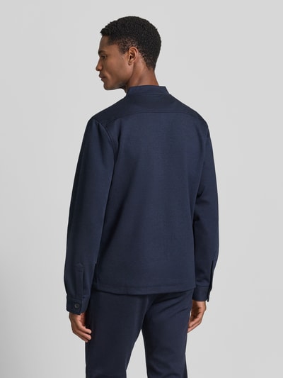 Męski model nosi Regular Fit Sweatjacke mit Stehkragen von Lindbergh, elastyczna mieszanka materiałów, ciemnogranatowy kolor, wpuszczane kieszenie, zamek błyskawiczny, długość tyłu w rozmiarze M: 69 cm, długość rękawów w rozmiarze M: 66 cm, widok całej sylwetki z tyłu.