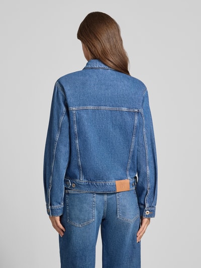Männermodel trägt kurtka jeansowa z bawełny, krój regular fit, model 'Saima' od MOS MOSH, niebieska, z wykładanym kołnierzem, kieszeniami na piersi i listwą guzikową, Długość tyłu w rozmiarze S: 56 cm, szerokość ramion w rozmiarze S: 43 cm, szerokość klatki piersiowej w rozmiarze S: 50 cm, długość rękawów w rozmiarze S: 60 cm, całkowity widok z tyłu