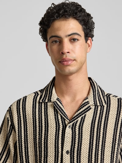Mannelijk model draagt Regular Fit vrijetijdsoverhemd uit katoenmix model 'DANI' van Only & Sons, all-over motief, gestreept, knitwearstructuur, reverskraag, enkele knopenrij, korte mouw, beige met zwarte strepen, frontale close-up.