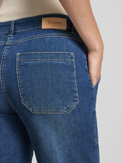 Frauenmodel trägt Jeans in 7/8-Länge Modell 'Liv Wide' von TONI aus Baumwoll-Elasthan-Mix mit Eingrifftaschen, Detailaufnahme Rückansicht.