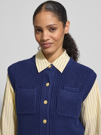 Frauenmodel trägt Regular Fit Strickweste aus reiner Baumwolle von Tommy Hilfiger, Optik: Unifarben, Logo-Applikation, Materialverarbeitung: Strick, Nahaufnahme Oberkörper.