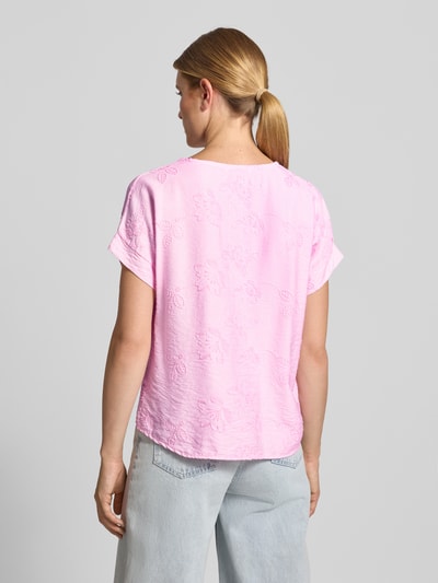 Männermodel trägt Regular Fit T-Shirt aus mieszanka wiskozy Model 'Anni' od ZABAIONE, kwiatowy haft na całej powierzchni, tył wydłużony, okrągły dekolt, kolor różowy, długość tyłu w rozmiarze S: 60 cm, Ganzkörperansicht Rückansicht.