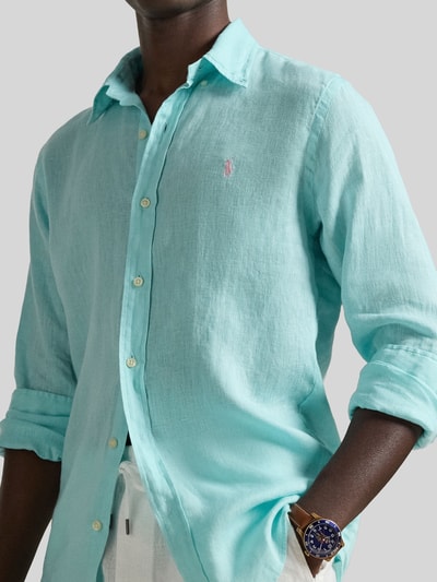 Mannelijk model draagt Regular Fit vrijetijdsoverhemd uit puur linnen van Polo Ralph Lauren in effen kleuren met logodetail, knoopsluiting en lange mouwen, materiaalverwerking gevlamd garen, custom fit, voorkant bovenlichaam close-up.
