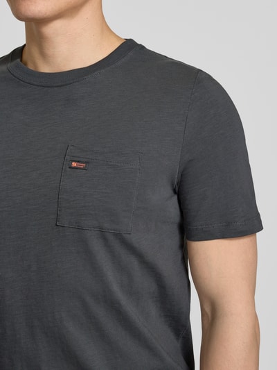 Mężczyznamodel nosi Regular Fit T-Shirt aus reiner Baumwolle von s.Oliver RED LABEL, jednokolorowy, naszywka z logo, okrągły dekolt, krótki rękaw, brustasza, bawełna, Nahaufnahme Oberkörper.