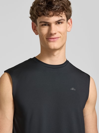 Männermodel trägt Relaxed Fit Top mit Logo-Print Modell 'OLIOS' von Ellesse im Elastischer-Material-Mix, Rundhalsausschnitt, Nahaufnahme Oberkörper.