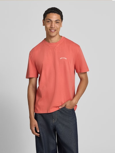Männermodel trägt leuchtend orangerotes Regular Fit T-Shirt aus reiner Baumwolle Modell 'John Tee' von Pepe Jeans, Herren T-Shirt, Ganzkörperansicht von vorne.