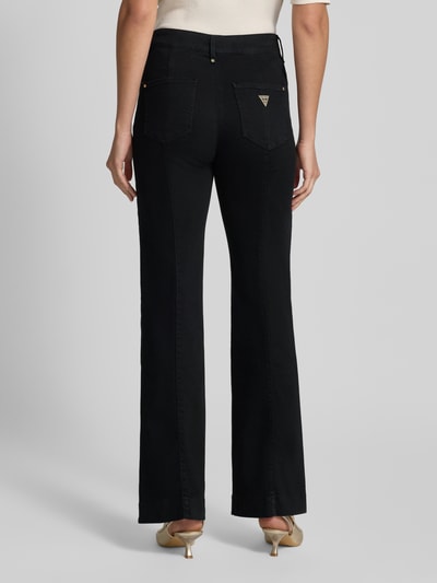 Frauenmodel trägt High Waist Palazzo Jeans mit seitlichen Knöpfen von GUESS in Schwarz, Baumwoll-Mix, Ganzkörperansicht Rückansicht. Modell 'NEW FAYE', Stretch-Anteil, Bundweite 38 cm, Innenbeinlänge 81 cm.