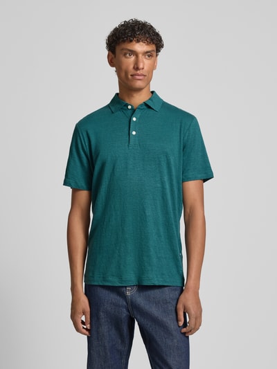 Männermodel trägt Slim Fit Poloshirt aus Leinen-Elasthan-Mix von OLYMP Level Five, grün, Knopfleiste, 1/2-Arm, Rückenlänge 70 cm, Ganzkörperansicht von vorne.
