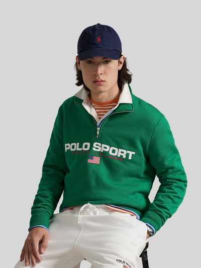 Männermodel trägt Relaxed Fit Troyer aus Baumwoll-Mix von Polo Ralph Lauren in Grün, unifarben, Label Print, Nahaufnahme Oberkörper.