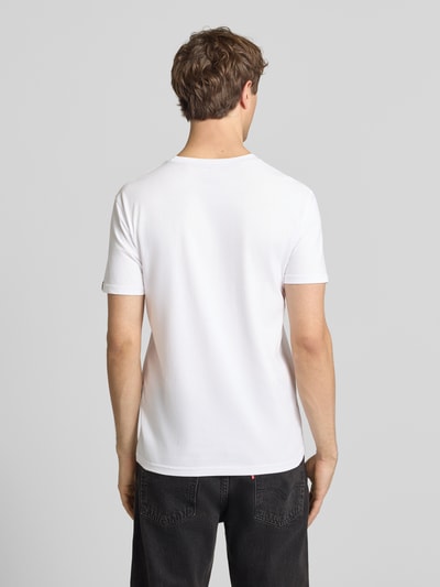 Männermodel trägt Herren T-Shirt mit Label-Detail Modell 'Foam' von Alpha Industries, Reine Baumwolle, Gerader-Schnitt, Rückenlänge 67 cm, Ganzkörperansicht Rückansicht.