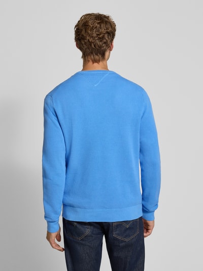 Mężczyzna nosi Regular Fit Pullover aus reiner Baumwolle von Tommy Hilfiger w kolorze jasnoniebieskim, widok całej sylwetki z tyłu.