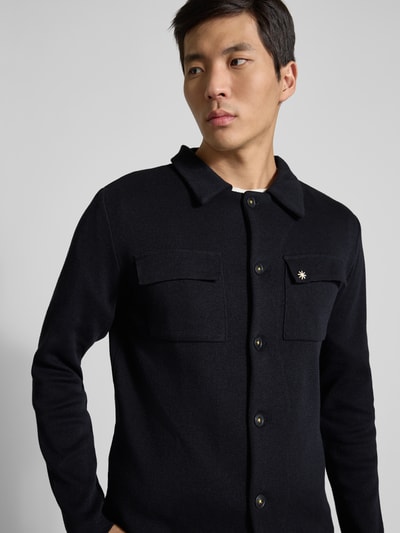 Männermodel trägt Regular Fit Hemdjacke mit Brusttaschen von Manuel Ritz, schwarze Baumwoll-Mix-Oberfläche, Nahaufnahme Oberkörper.