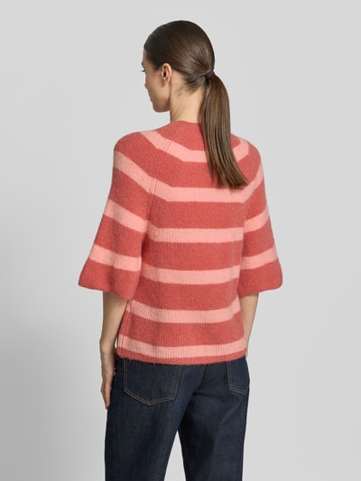 Frauenmodel trägt Strickpullover mit 1/2-Arm Modell 'Milania Hope' von MSCH Copenhagen, Material-Mix mit Alpaka-Anteil, Gerader-Schnitt, Rückenlänge 52 cm, Ärmellänge 36 cm, breite rosa und rote Streifen, weiche Textur, Nahaufnahme Rückansicht.