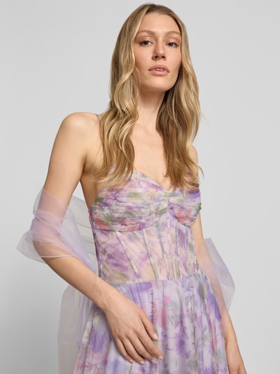 Frauenmodel trägt Corsagenkleid im Allover-Look von Mascara in zarten Lila- und Rosatönen, mit Drapierungen und Schal, Nahaufnahme Oberkörper.