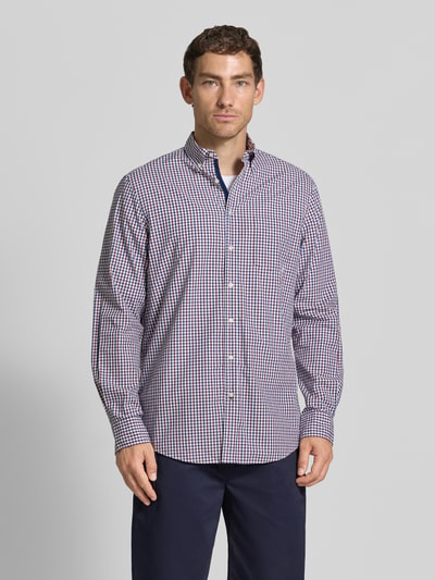 Męski model nosi Regular Fit Freizeithemd mit Button-Down-Kragen od Christian Berg Men, bawełna, kratka vichy, listwa guzikowa, krój regular fit, długość tyłu 80 cm, szerokość ramion 50 cm, długość rękawów 66 cm, widok całej sylwetki z przodu.