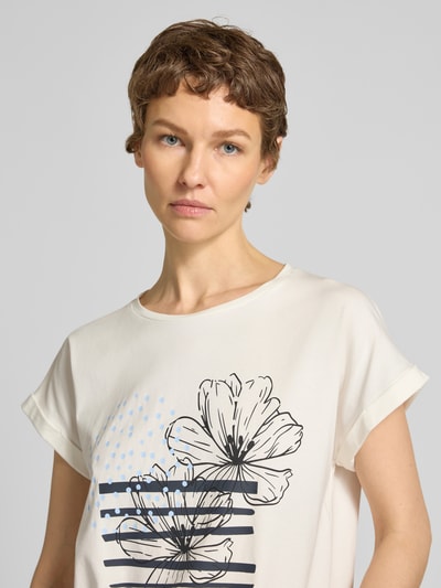 Frauenmodel trägt T-Shirt mit fixiertem Ärmelaufschlag Modell 'RINA' von Soyaconcept, Rundhalsausschnitt, Motiv-Print, Nahaufnahme Oberkörper.