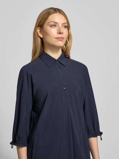 Kobiece modelka nosi Knielanges Hemdblusenkleid mit Knopfleiste von Marc Cain, mieszanka materiałów z dodatkiem streczu, prosty krój, długość do kolan, kołnierzyk koszulowy, listwa guzikowa, długość tyłu 101 cm, szerokość klatki piersiowej 54 cm, długość rękawów 42 cm, kolor granatowy, gładka tekstura, nahaufnahme górnej części ciała.