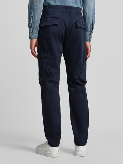 Männermodel trägt Straight Fit Cargohose aus Baumwoll-Mix von MCNEAL, dunkelblau, Taschen, Knopfverschluss, Ganzkörperansicht Rückansicht, elastischer Material-Mix
